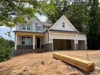 Charming two-story home featuring a 2-car garage, gray brick accents, and beautiful architectural details at 385 Riverwood Pass, Dallas, GA 30157