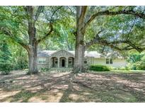 Charming stone home exterior with mature trees providing shade and curb appeal at 1110 Asbury St, Oxford, GA 30054