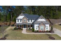 Beautiful two-story home featuring stone accents, a welcoming front porch, and a well-maintained landscaped yard at 6650 Canyon Cv, Cumming, GA 30028