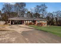 Charming brick home with a carport and well-manicured front yard at 4983 Arcado Sw Rd, Lilburn, GA 30047