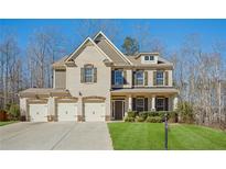Charming two-story home boasts a well-manicured lawn and a three-car garage at 3610 Ansley Manor Ct, Cumming, GA 30028