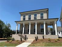 Charming two-story home with brick facade, covered porch and black railing at 118 Stonehouse Drive Way, Cumming, GA 30040