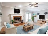 Cozy living room featuring a brick fireplace, ceiling fan, and neutral color palette at 134 Springstead Ct, Marietta, GA 30060