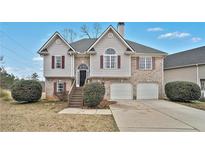 Charming two-story home with brick accents, a well-maintained yard, and a two-car garage at 5990 Tate Dr, Austell, GA 30106