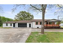 Charming white-painted home with a covered porch, black garage door, and inviting curb appeal at 43 George Lemon Dr, Mcdonough, GA 30253