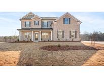 Charming brick two-story home featuring a welcoming front porch and nicely manicured yard at 804 Dobby Way (Lot 103), Mcdonough, GA 30252