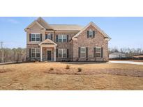 Traditional two-story brick home with gray shutters and manicured lawn at 816 Dobby Way (Lot 100), Mcdonough, GA 30252