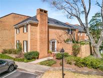Charming brick townhome featuring a well-maintained yard, chimney, and inviting entrance at 19 Lullwater Ne Pl, Atlanta, GA 30307