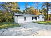 Charming single-story home with a freshly painted white exterior and a spacious front yard and driveway at 4781 Brownsville Rd, Powder Springs, GA 30127