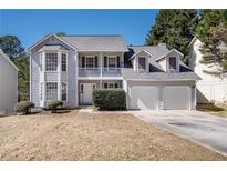 Charming two-story home with a welcoming front porch and a two-car garage at 613 Lone Oak Dr, Lithonia, GA 30058