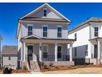 Charming two-story home with light blue siding, a covered front porch, and professionally landscaped yard at 104 Stonehouse Dr, Cumming, GA 30040