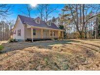 Charming home featuring a covered front porch, red shutters and a metal roof at 436 Tarpley Ave, Bowdon, GA 30108
