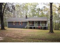 Charming exterior of a single-story home featuring a cozy front porch and manicured lawn at 823 Mount Tabor Rd, Oxford, GA 30054