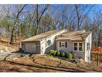 Charming home featuring a two-car garage, neutral siding, unique round window and a small deck at 920 Pine Grove Pointe Dr, Roswell, GA 30075