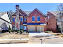 Charming brick home with a stone chimney, two-car garage, and manicured front lawn at 4892 Kentwood Dr, Marietta, GA 30068