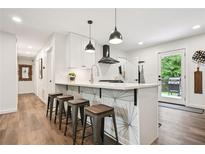 Modern kitchen with white cabinets, breakfast bar and stainless steel appliances at 3314 Creatwood Se Trl, Smyrna, GA 30080