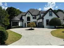 Stunning two-story home featuring a circular driveway and manicured lawn at 6045 Standard View Dr, Johns Creek, GA 30097