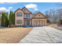 Charming two-story home with well-maintained lawn, two-car garage, and inviting curb appeal at 6640 Grove Crossing Ct, Cumming, GA 30028