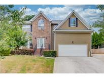 Charming two-story home featuring a brick facade, well-manicured lawn, and attached two-car garage at 114 Farm Valley Dr, Canton, GA 30115