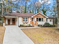 Charming renovated ranch-style home with updated white brick and a cozy front porch and landscaped front yard at 1428 Downs Sw Dr, Atlanta, GA 30311