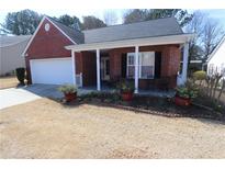 Charming single-story brick home with a covered front porch and attached garage at 709 Jacoby Dr, Loganville, GA 30052