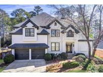 Stunning two-story home with black trim, lush landscaping, and a two-car garage at 18 Peppertree Ct, Marietta, GA 30068