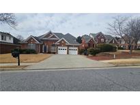 Charming single-story brick home features a manicured lawn and two-car garage at 2604 Harman Park Cir, Duluth, GA 30097