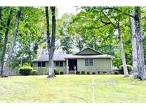 Charming single story home with lush green yard and mature trees surrounding the property at 1312 La Mesa Dr, Lawrenceville, GA 30043