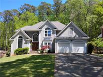 Charming two-story home with a manicured lawn, an attached two-car garage, and mature trees at 1470 Sweet Bottom Sw Cir, Marietta, GA 30064