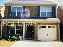 Charming two-story brick home with attached garage and manicured front yard at 312 Lauren Dr, Fairburn, GA 30213