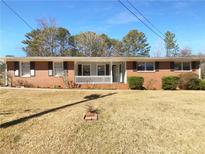 Charming brick home featuring a well-maintained front yard with mature trees and a cozy porch at 6691 Birch Dr, Winston, GA 30187