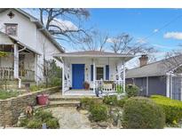 Charming home featuring a cozy front porch with a blue door and well-manicured landscaping at 818 Virgil Ne St, Atlanta, GA 30307