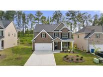 Charming two-story home with brick and siding, complemented by a well-manicured lawn and attached two-car garage at 1868 Lacebark Elm Way, Lawrenceville, GA 30045