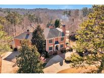 Stately red brick home featuring manicured grounds, mature trees, and driveway at 3832 Wesley Chapel Rd, Marietta, GA 30062