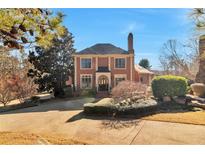 Elegant brick home boasts a classic design with a manicured front yard and a welcoming driveway at 3832 Wesley Chapel Rd, Marietta, GA 30062