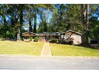 Charming single-story home surrounded by mature trees and a lush green lawn, enhancing its curb appeal at 2234 Clifton Springs Mnr, Decatur, GA 30034