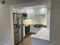 Bright kitchen features stainless steel appliances, white cabinetry and stone countertops at 145 Amherst Nw Pl, Atlanta, GA 30327