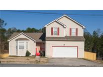 Charming two-story home with red shutters, red trimmed garage and entry, landscaped front yard, and ample parking at 5546 Wellborn Creek Dr, Lithonia, GA 30058