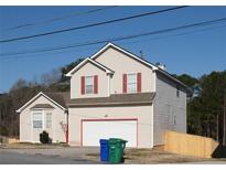 Two story home with vinyl siding, a garage and red trim highlights at 5546 Wellborn Creek Dr, Lithonia, GA 30058