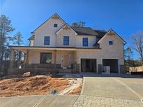 Two-story home with a brick and siding exterior, front porch, and two-car garage at 3677 Thornhill Ct, Douglasville, GA 30135