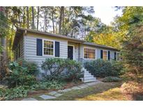 Charming home featuring stone walkway, landscaped front yard, and cozy, neutral colored exterior at 1031 Lindridge Ne Dr, Atlanta, GA 30324