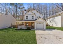 Charming two-story home with a front porch, attached garage, and well-manicured lawn at 851 Ashley Ln, Stone Mountain, GA 30087