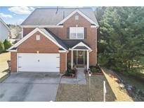 Inviting two-story brick home with a well-manicured lawn and attached two-car garage at 1039 Bramble Way, Grayson, GA 30017