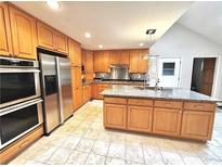 This kitchen has wood cabinets, stainless steel appliances, a tile backsplash, and granite countertops at 4341 Kings Ne Way, Marietta, GA 30067