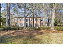 Traditional red brick home with a manicured lawn and mature trees, offering classic curb appeal at 160 Wing Mill Rd, Sandy Springs, GA 30350