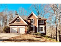 Stately brick home featuring a two-car garage, manicured landscaping, and architectural details at 6302 Manassas Nw Pass, Acworth, GA 30101