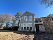 Inviting two-story exterior with large windows and charming stone accents under a bright blue sky at 2115 Canyon Point Cir, Roswell, GA 30076
