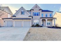 Beautiful two-story home with a three car garage and manicured lawn at 3540 Paddocks Pkwy, Suwanee, GA 30024