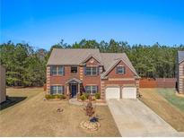 Charming brick two-story home featuring an attached two-car garage and a well-manicured lawn at 403 Sonja Ln, Loganville, GA 30052