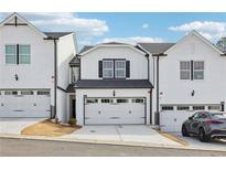 New construction white townhomes boast attached garages and well-maintained landscaping at 6379 Apalachee Se Way, Smyrna, GA 30126